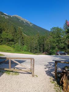 a wooden bench sitting on the side of a road at Valvasorjev dom pod Stolom in Žirovnica