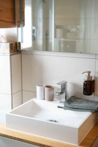 La salle de bains est pourvue d'un lavabo blanc et d'un miroir. dans l'établissement eleven Marquartstein, à Marquartstein