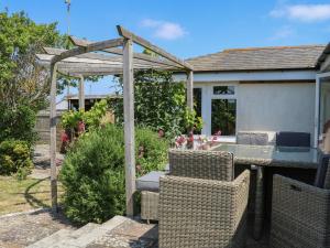 a patio with a table and chairs and a pergola at 50 Harbour Road in Bognor Regis