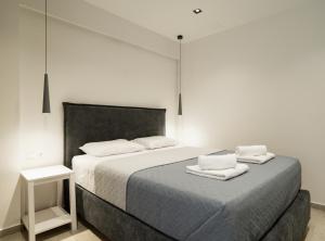 a bedroom with a bed with two towels on it at Noema Urban Living in Heraklio