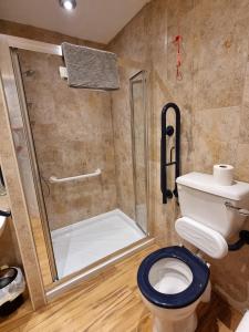 a bathroom with a toilet and a shower at Granada Apartments Berkeley in Blackpool