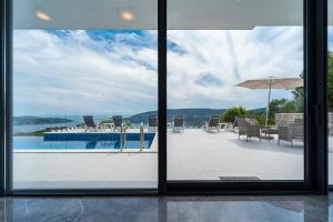 a view of a swimming pool through a window at Villa Trebesin in Herceg-Novi