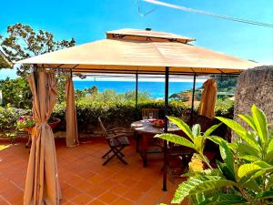 ein großer Sonnenschirm auf einer Terrasse mit Tisch und Stühlen in der Unterkunft MAD di Mare di Arte Dormire in Celle Ligure