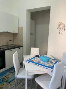 eine Küche mit einem weißen Tisch und weißen Stühlen in der Unterkunft La Casa di Giusy in Lampedusa