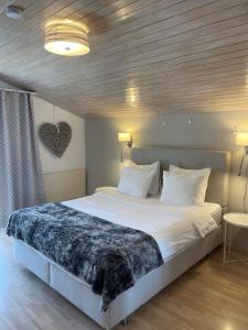 una camera da letto con un grande letto con lenzuola bianche di S&P Mountain View Apartment 2 a Wilderswil