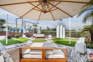 un patio con mesa y sombrilla en La mejor ubicación con alberca caliente, gym, bar, en Ciudad de México