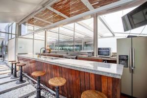 uma cozinha com um balcão com bancos e um frigorífico em La mejor ubicación con alberca caliente, gym, bar em Cidade do México