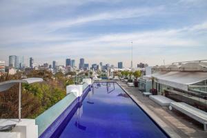 una piscina en la parte superior de un edificio con vistas al perfil urbano en La mejor ubicación con alberca caliente, gym, bar, en Ciudad de México