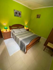 カストロポルにあるBajo apartamentos Casa Paquitaの緑のベッドルーム(ベッド1台、ランプ2つ付)