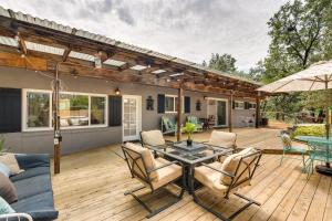 un patio con mesa y sillas en una terraza de madera en Modern Meadow Vista Vacation Home with Spacious Deck, 