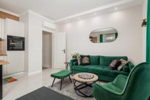 ein Wohnzimmer mit einem grünen Sofa und einem Tisch in der Unterkunft Deluxe Kvarner 2 in Lovran