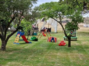 a park with playground equipment in the grass at River rooms kriaritsi in Skála Sikiás