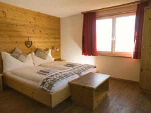 Un dormitorio con una cama grande y una ventana en Hotel Aletschhorn en Belalp