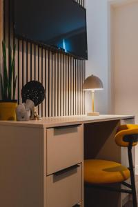 escritorio con monitor, lámpara y silla en Must See Vibrant Contemporary Two Bed Apartment, en Leicester