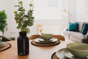 uma mesa de madeira com tigelas e um vaso com uma planta em Must See Vibrant Contemporary Two Bed Apartment em Leicester