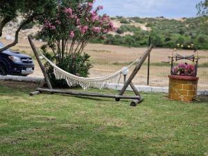 a hammock sitting in the grass in a yard at River rooms kriaritsi in Skála Sikiás