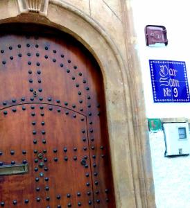 drewniane drzwi w budynku z napisem w obiekcie Dar Sam - Red Room w mieście Rabat