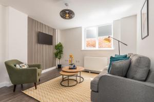 uma sala de estar com um sofá e duas cadeiras e uma mesa em Must See Vibrant Contemporary Two Bed Apartment em Leicester