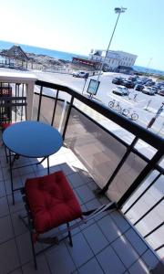 Un balcón con una mesa azul y una silla roja. en Le Belvédère de Port-Lin - Les Gîtes de la Côte d'Amour, en Le Croisic 9 fotos más