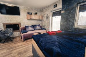 ein Schlafzimmer mit einem Bett, einem Sofa und einem TV in der Unterkunft Penzion V Hádance in Velké Pavlovice