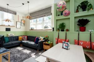 a living room with a couch and a table at 1 The Old Schoolhouse for 5+cot; hot tub, parking, pets in Whitstable