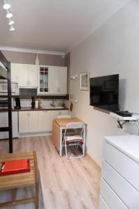 a kitchen with white cabinets and a table in it at Nid Douillet classé 2 étoiles depuis janvier 2023 in Le Mont-Dore
