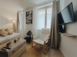 sypialnia z łóżkiem, krzesłem i telewizorem w obiekcie Cosy Appartement 4P proche 12eme/Vincennes w mieście Charenton-le-Pont