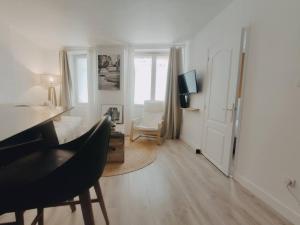 een witte woonkamer met een bureau en een stoel bij Cosy Appartement 4P proche 12eme/Vincennes in Charenton-le-Pont