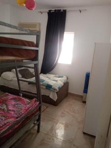 um pequeno quarto com um beliche e uma janela em شاليه بقرية كورونادو مارينا - Coronado Marina عائلات فقط em Ain Sokhna