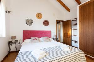 1 dormitorio con 1 cama blanca grande y toallas. en CASA TIERRA - Casas Los Elementos, en Zahora