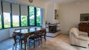 a dining room with a table and chairs and a couch at Alex House Garden in Iraklitsa