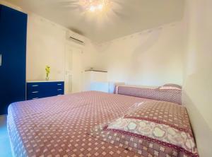 een slaapkamer met een bed met een paars dekbed bij Villaggio I Giardini del Conero in Porto Recanati