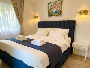 een slaapkamer met een groot bed en handdoeken bij Apartment Velvet - free private garage in Dubrovnik