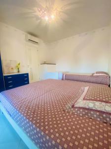 een slaapkamer met een groot bed met een paars dekbed bij Villaggio I Giardini del Conero in Porto Recanati