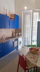 een keuken met blauwe kasten en een tafel met een fruitschaal bij Casa Migliore in Palermo