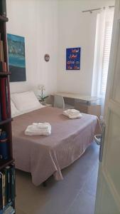 een slaapkamer met een bed met twee handdoeken erop bij Casa Migliore in Palermo