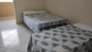 2 aparte bedden in een kamer met een tegelvloer bij 101 Apartamento em Aracruz ES in Aracruz