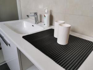 a bathroom sink with two rolls of toilet paper on a mat at Ferienwohnung Florine 