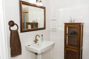 a white bathroom with a sink and a mirror at CASA RURAL EL ZARZOSO in Coria