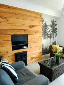 sala de estar con pared de madera y TV de pantalla plana en NEW! Beautiful City Apartment Santander, en Santander
