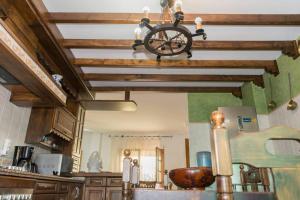 a kitchen with a ceiling with wooden beams and a chandelier at CASA RURAL EL ZARZOSO in Coria