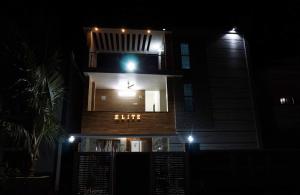 a building with a clock on the side of it at night at Elite Resort in Yelagiri