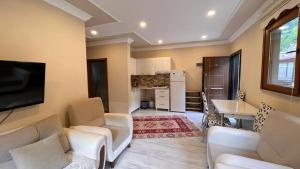 a living room with two white couches and a kitchen at Bahar Villa in Uzungol