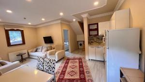 a living room with a white refrigerator and a kitchen at Bahar Villa in Uzungol