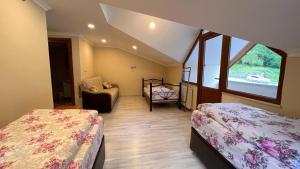 a bedroom with two beds and a chair and a window at Bahar Villa Pansiyon in Uzungöl