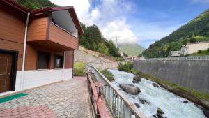 a river next to a house with a riverensional at Bahar Villa Pansiyon in Uzungöl