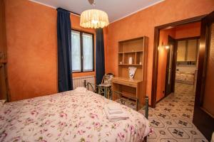 a bedroom with a bed and a desk and a window at GB - Dimora Fiorita in Armeno