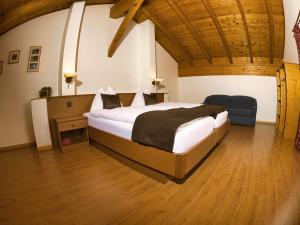 una camera con un grande letto e un soffitto in legno di Hotel Massa a Blatten bei Naters