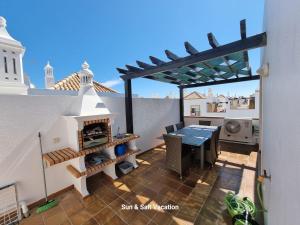 Cabanas de Tavira Smashing 2 bed, 2 bath, Duplex Penthouse في كاباناس دي تافيرا: فناء على طاولة ومدفأة على السطح