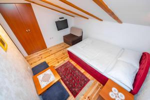 - une petite chambre avec un lit et une chaise dans l'établissement Guesthouse Sandra, à Kolašin